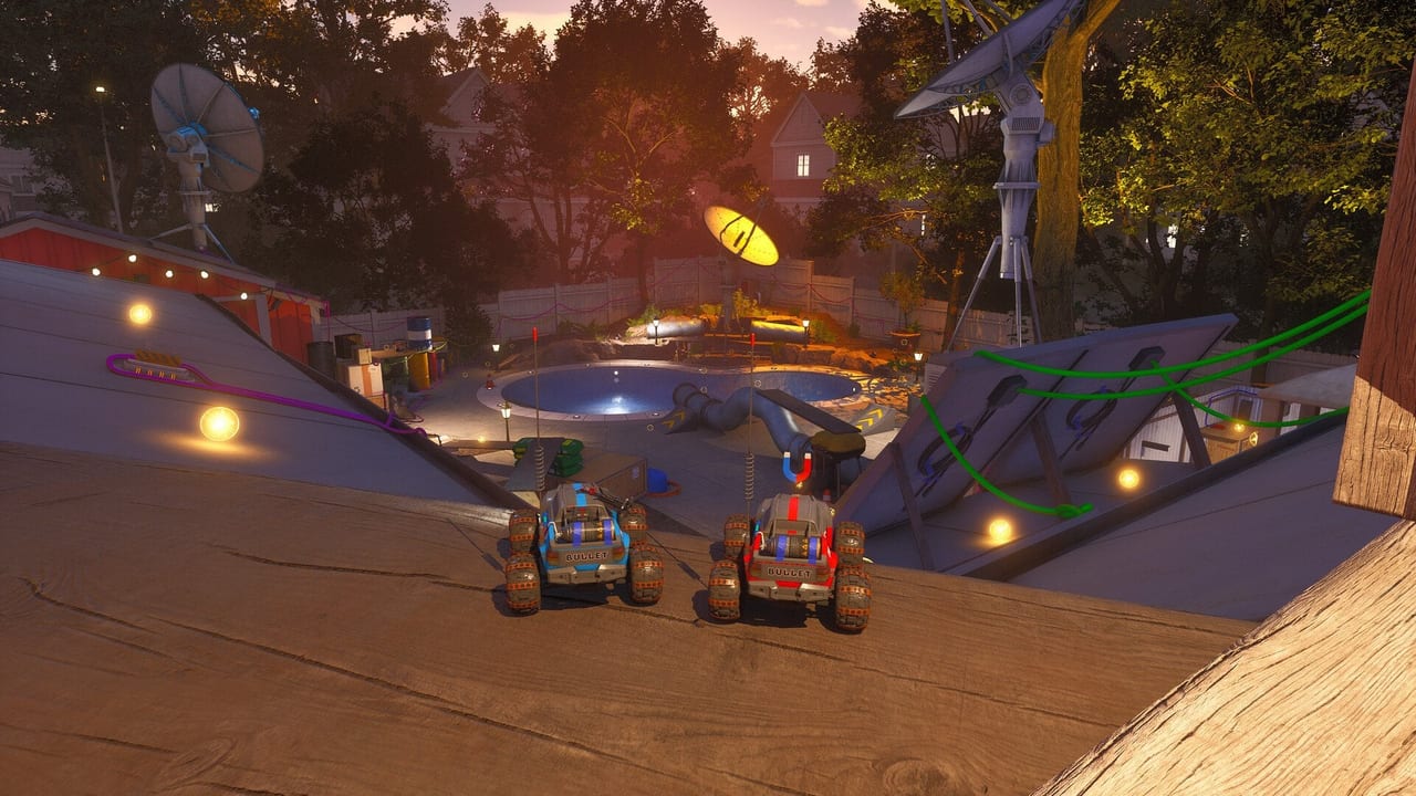 Two WheelMates RC cars overlooking a backyard pool, ramps, and dishes at dusk